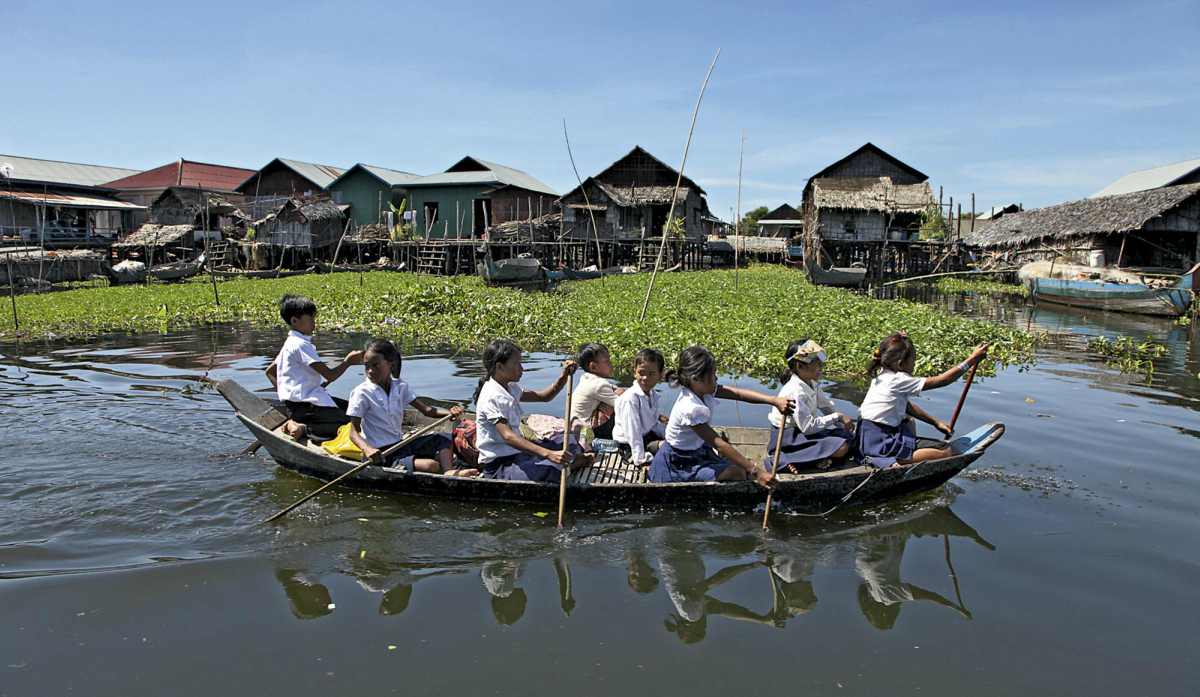 Crianças a deslocarem-se para a escola numa aldeia flutuante do Tonle Sap